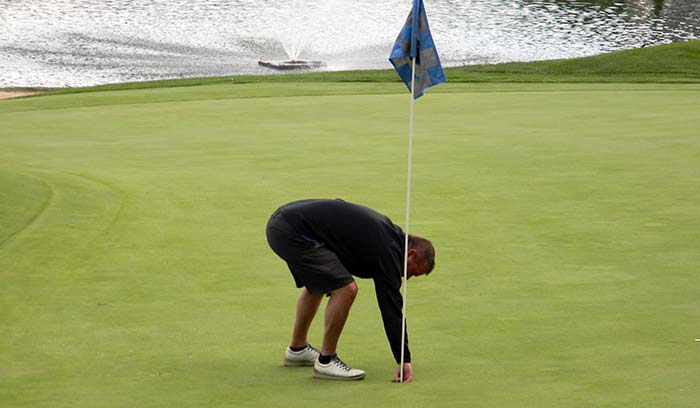 Dan Marr picks his bomb putt out of the cup