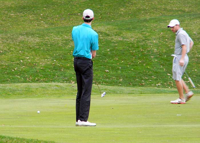 Nick Adkins rolls his birdie effort on 13 as Brandon Nixon watches in the 2018 Fox Den Spring 2-M Scramble