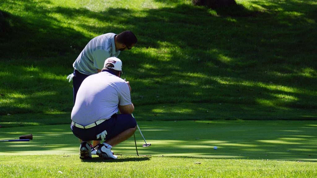 Jimmy Wild watches partner AJ Borisa putt