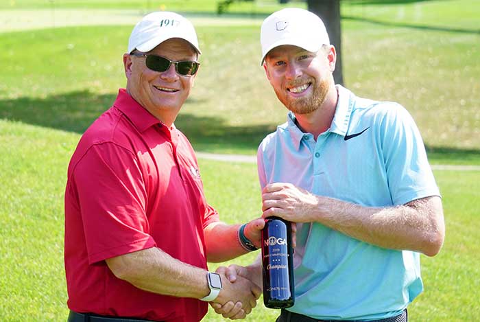 Robb Schulze presents a wine trophy to Sean McGuire for the 2019 NOGA Tour Championship