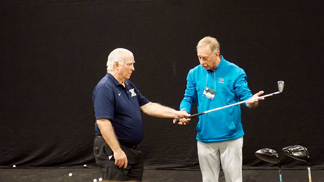 PGA pro Tom Kochensparger (r) offers a lesson at the Cleveland Golf Show.