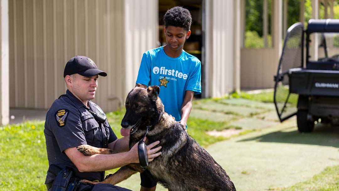 K9 Titus and a Trooper from the Ohio State Highway Patrol interact with a Putting with Police attendee. 